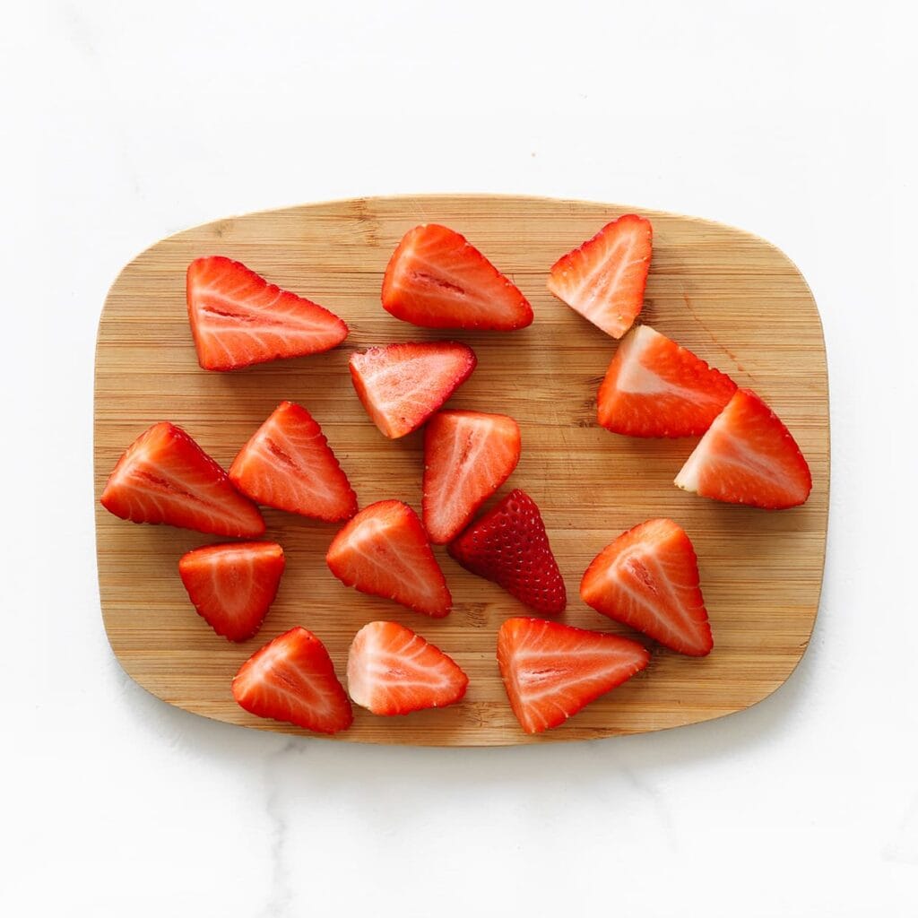 Was de aardbeien, snijd ze in stukjes en dep ze droog.