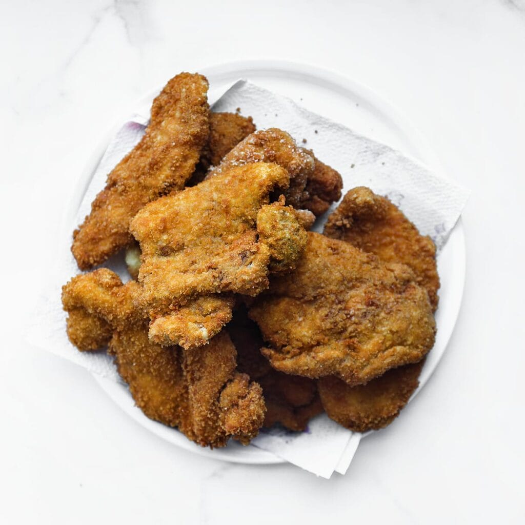 Verhit een laagje zonnebloemolie in een koekenpan op middelhoog vuur (175 °C). Bak de kip aan beide kanten goudbruin en gaar.