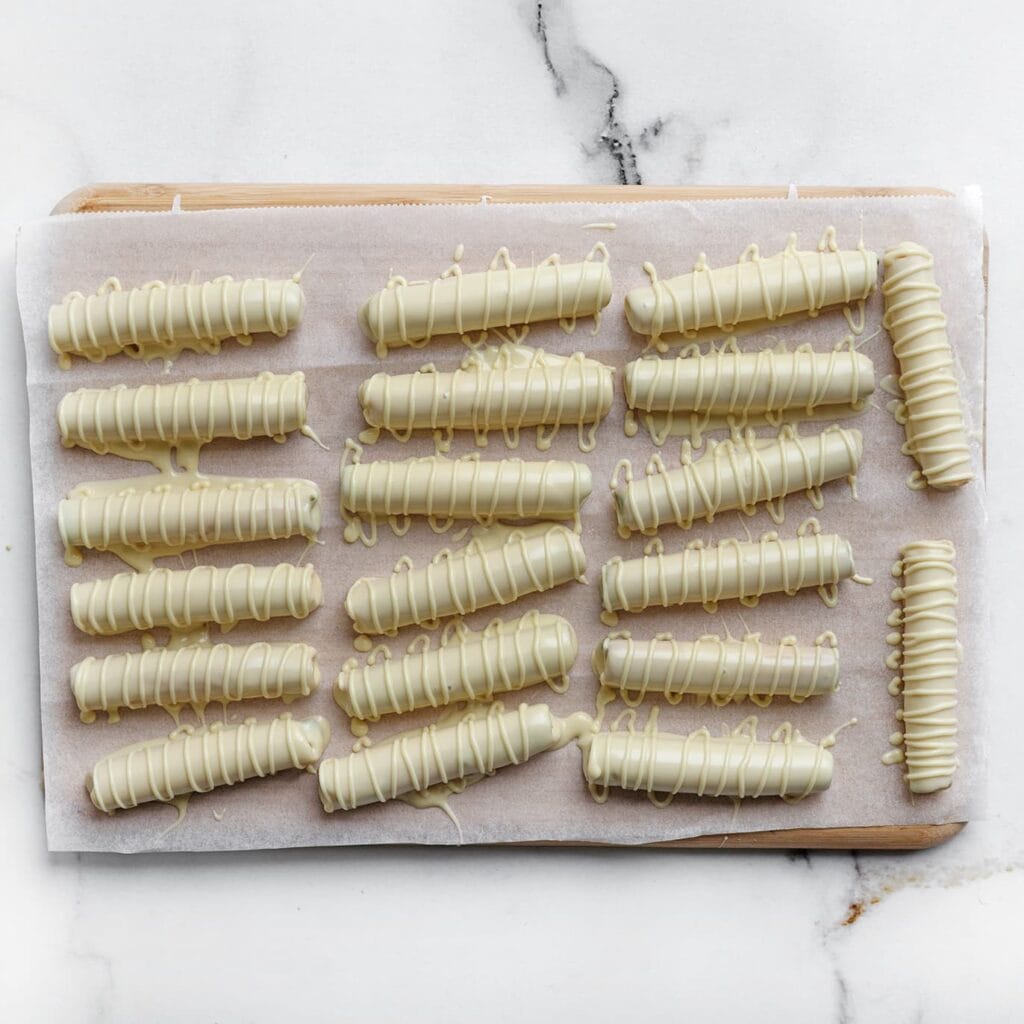 Laat de chocolade uitharden op kamertemperatuur of zet de koekjes kort in de koelkast voor een sneller resultaat.