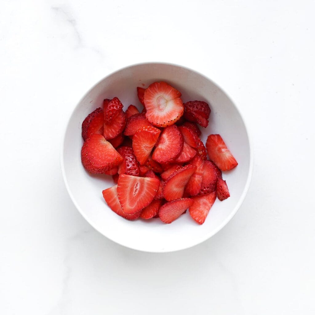 Snijd de aardbeien in stukjes.