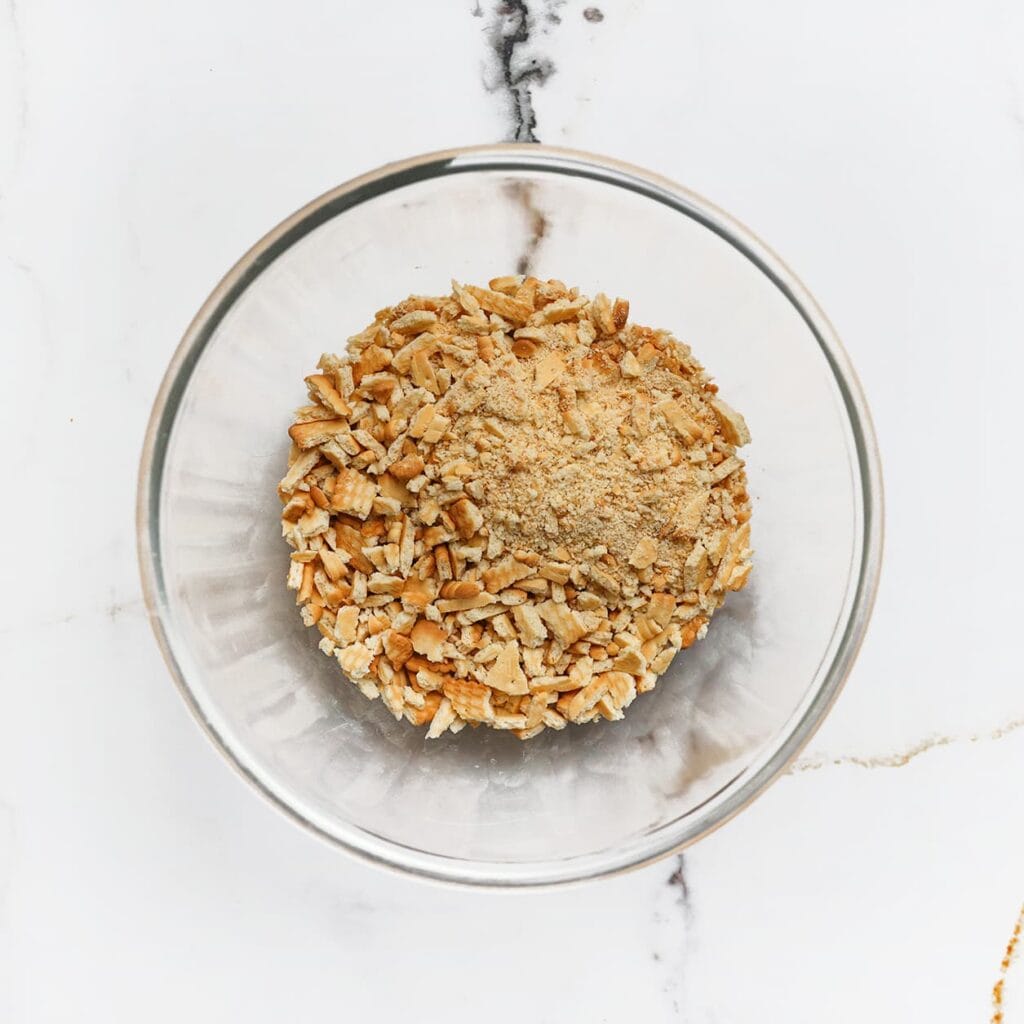 Snijd de maria biscuit in grove stukjes en doe ze in een diepe kom. Ze hoeven niet allemaal even groot te zijn, maar zorg ervoor dat er geen hele koekjes meer tussen zitten.