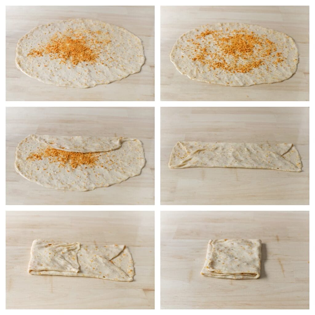 Strooi wat van de nacho-kruimels over het deeg. Vouw de boven- en onderkant naar het midden tot een rechthoek. Vouw daarna de zijkanten naar binnen tot een vierkant pakketje.