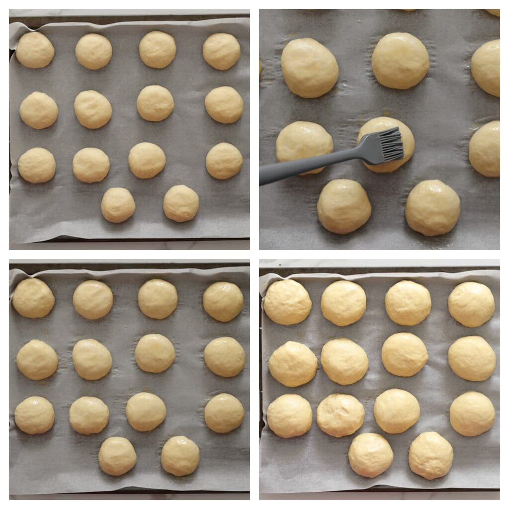 Leg de bollen op een bakplaat met bakpapier. Bestrijk ze met het geklutste ei en laat nogmaals 30 minuten rijzen, of tot ze in omvang zijn verdubbeld.